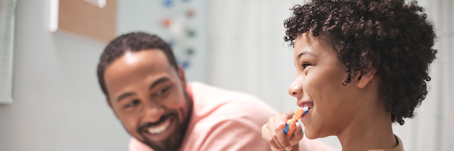 father and son brushing teeth