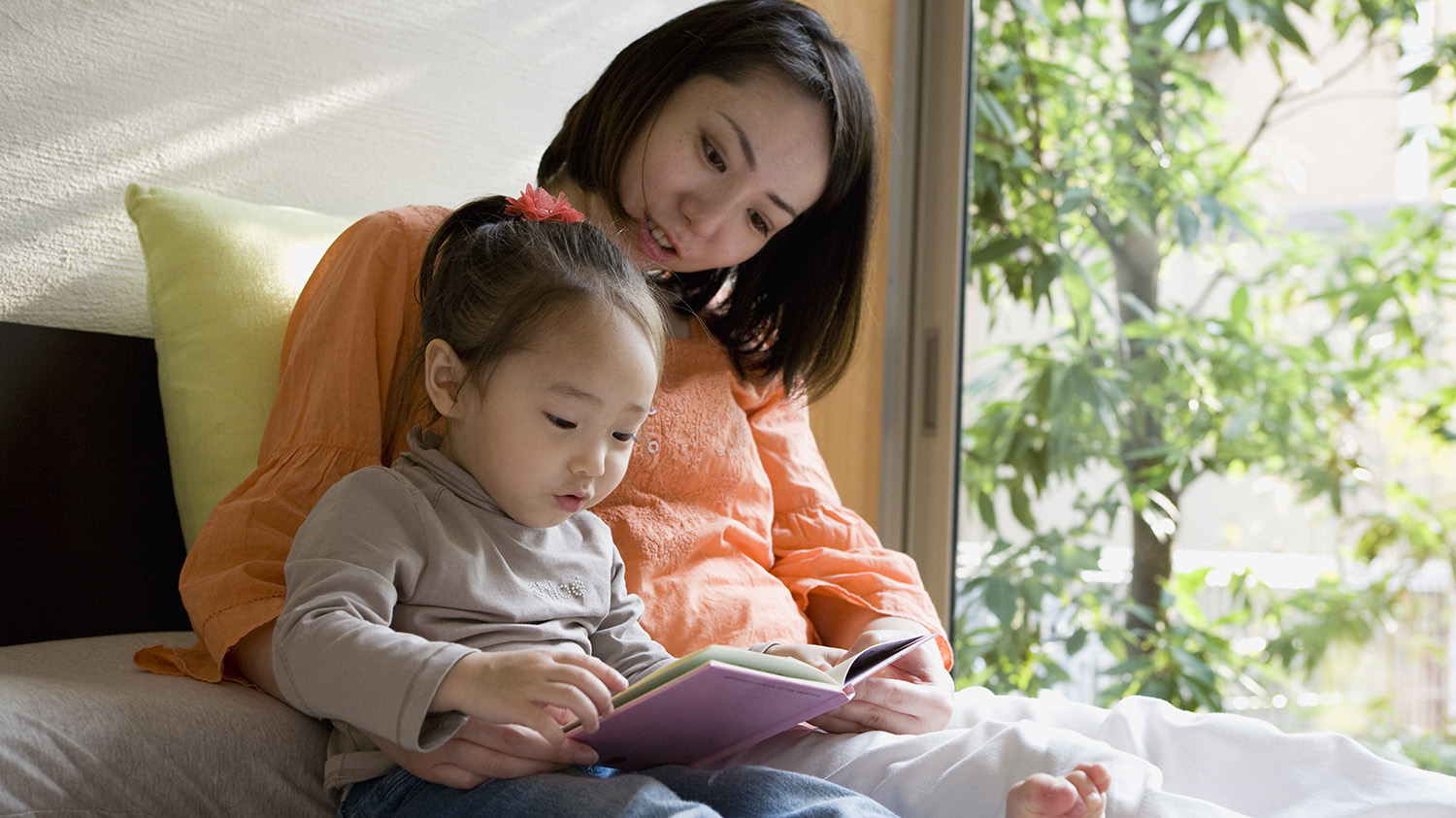 Mom reading to her daughter.